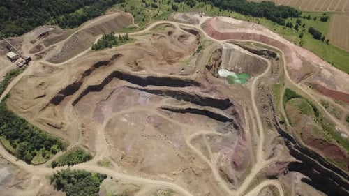 Aerial shot with camera tilt-down of the open-pit melaphyr mining quarry