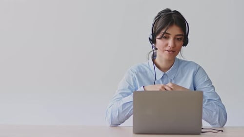 Woman in Headset Communicating on Laptop