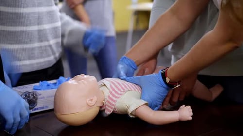 CPR Training on Baby Doll with Medical Professionals