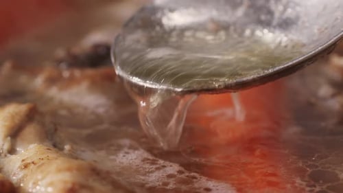 Spoon Lifting Broth From a Hot Pot of Stew