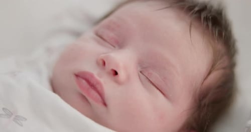 Baby, sleeping face and nursery bed with morning, nap and dreaming of a young newborn at home