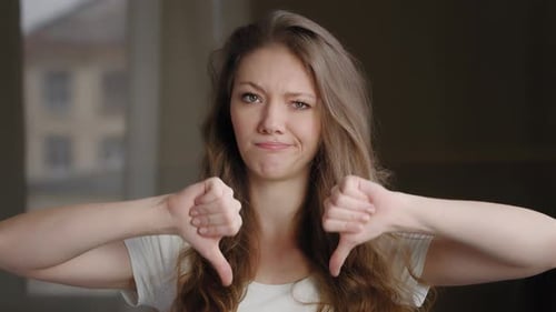 Young Woman Gives Double Thumbs Down Gesture