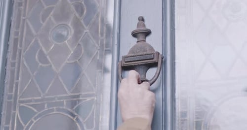 Courier using door knocker on traditional front door