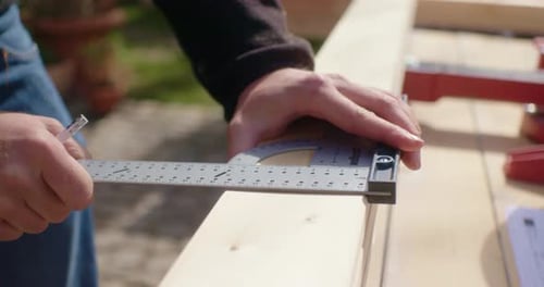 Adult Marking Wood with Measuring Square and Pencil