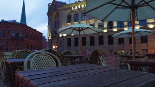 A Picturesque Outdoor Evening Cafe with Charming Ambiance at the City Center Featuring Empty Tables