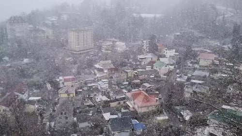Nasser Schnee bedeckt die Straßen und Häuser einer Kleinstadt bei Weihnachten, Schneefall und Magischem