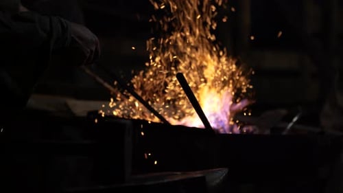 Blacksmith Shaping Metal with Fire and Sparks