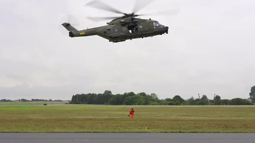 Rescue helicopter crew rescuing ground crew via wire lifting