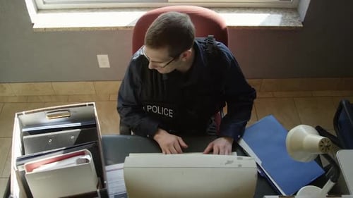 Police Officer Stressed at His Desk