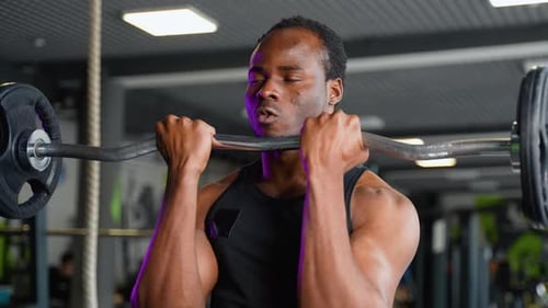 Joven musculoso levantando pesas Un hombre entrena bíceps