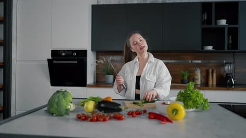 Woman Cutting Vegetables and Dancing in Kitchen