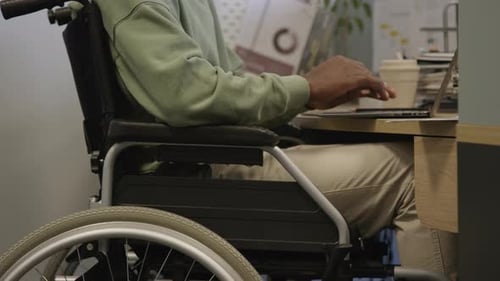 Wheelchaired Man Working on Laptop in Office