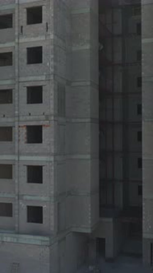 Vertical Drone View of Urban Construction Site with Unfinished Residential Buildings and Materials