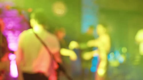 Blurred People Dancing with Lights at Party