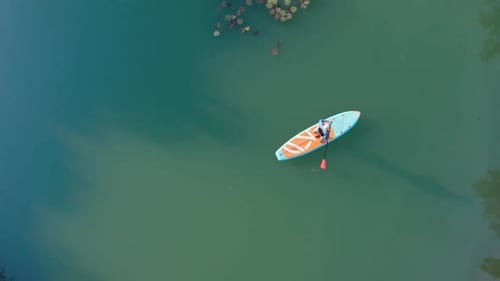 Man Stand and Rowing on SUP Surfboard
