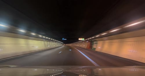 Driving a Car in the Through Wide Illuminated Tunnel Speeding on Highway