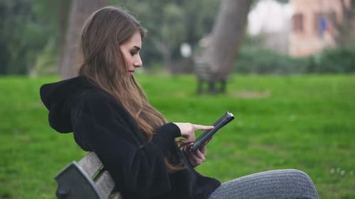 Woman Using Tablet on Park Bench