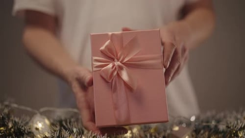 Woman Opening a Pink Gift Box with Ribbon