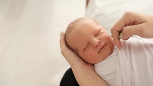 Newborn Baby Sleeping Peacefully in Gentle Hands