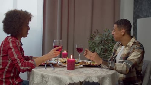 Couple afro-américain romantique célébrant et portant un toast avec des verres à vin