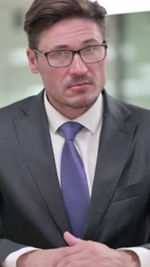Adult Man in Suit and Tie Talks to Camera