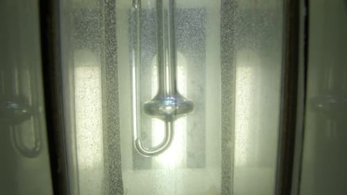 Glass Hydrometer Floating in Liquid Close Up