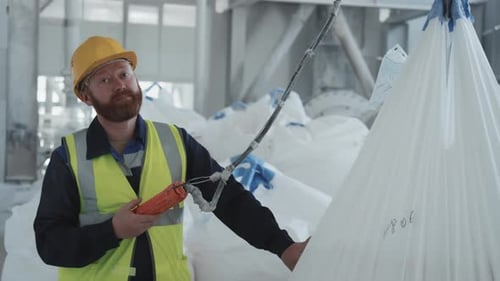 Factory Worker Using Lifting Hoist