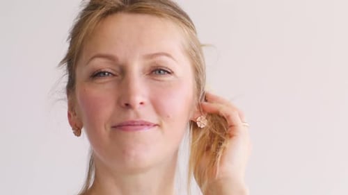 Smiling Woman Touching Her Blonde Hair Indoors