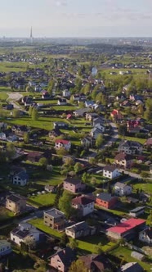 Vertical drone orbit over Katlakalns suburb houses with Riga Radio and TV Tower and Daugava River