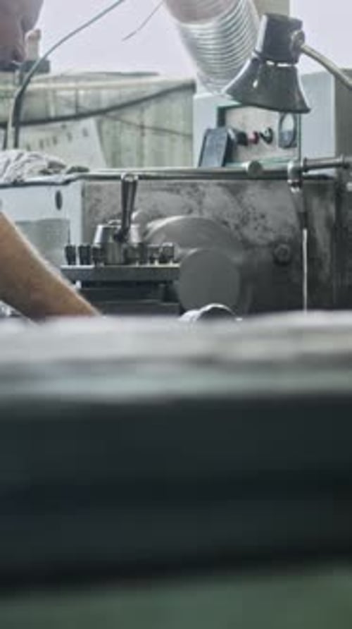 Metalworker operating lathe machine in workshop for precision engineering