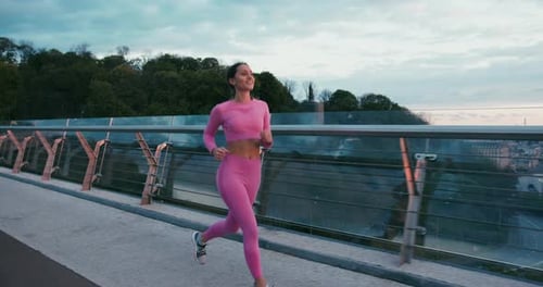 Longhaired Woman Running on Evening Pedestrian Bridge