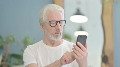 Senior Man Using Smartphone Indoors