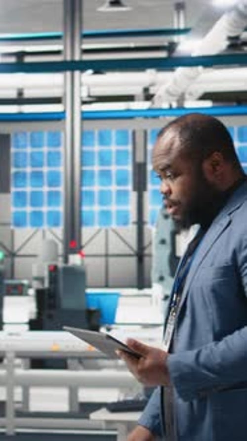 Vidéo verticale Un expert de l'industrie afro-américaine examine une chaîne de montage photovoltaïque