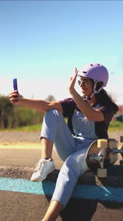Woman Waving on Phone at Skate Park