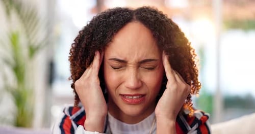 Woman Holds Temples in Headache Pain