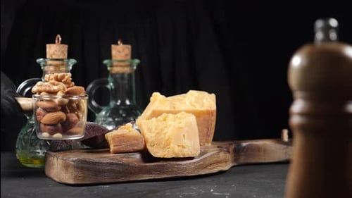 Restaurant Concept Table Setting Pieces of Cheese Decorated are on Black Background with Nuts and