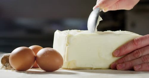 A chef prepares curls of butter to make a cake in a professional kitchen.Concept of: butter, sweet