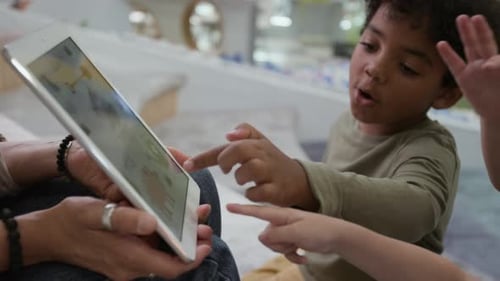 Kids Looking at Digital Tablet when Learning Alphabet with Teacher Indoors