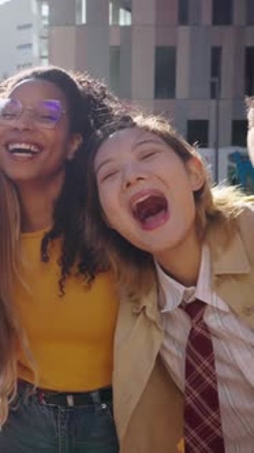 Laughing Group of Young Diverse Friends Looking Joyful at Camera Having Fun Together at City Street