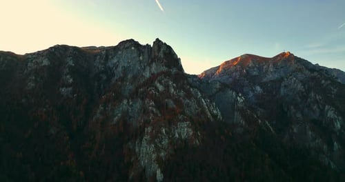Bucegi Mountains in Romania, sunset illuminating ridge. drone flight.