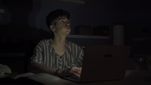 Teenager Studies Using Laptop at Night
