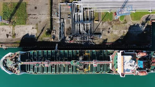 Top Down View of an Oil Tanker Being Refueled with Oil Products for Transportation