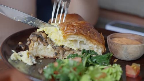 Close up of Person Cutting Savory Croissant