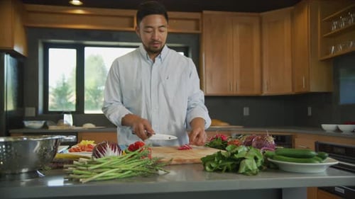 Man Prepares Fresh Vegetables in Bright Kitchen