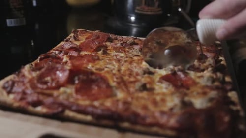 Slicing A Newly Baked Delicious Pepperoni Thin Crust Pizza- Close Up Shot