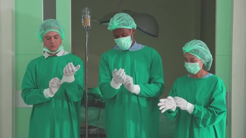Medical Team Prepares, Putting on Surgical Gloves