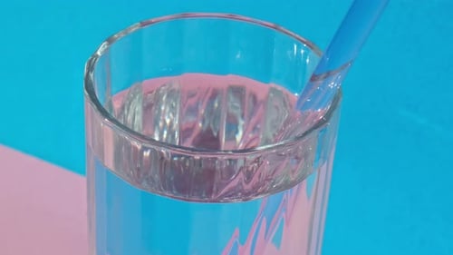 Juego de pajitas de vidrio reutilizables sobre fondo azul para beber agua a partir de pajitas ecológicas con