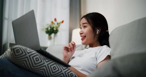 Woman Laughing and Video Chatting on Laptop at Home