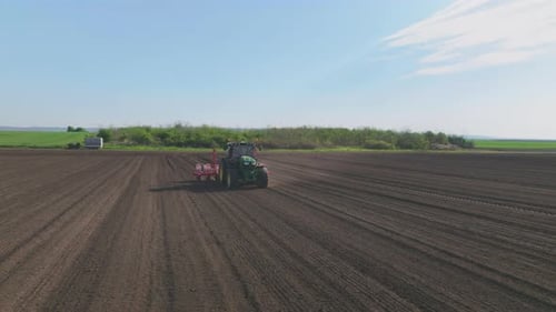 Tractor Tilling Field on Sunny Day