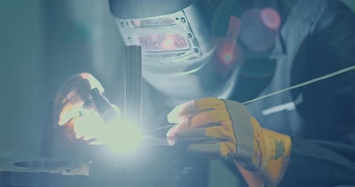 Professional Men in Welding Masks and Gloves Work in the Workshop with Arc Welding and Argon